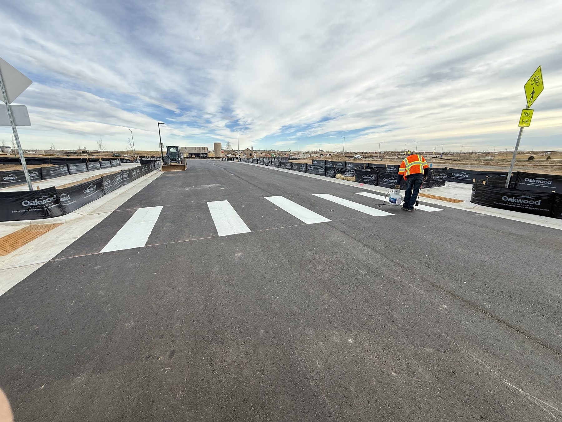 Crew painting a new crosswalk on fresh asphalt